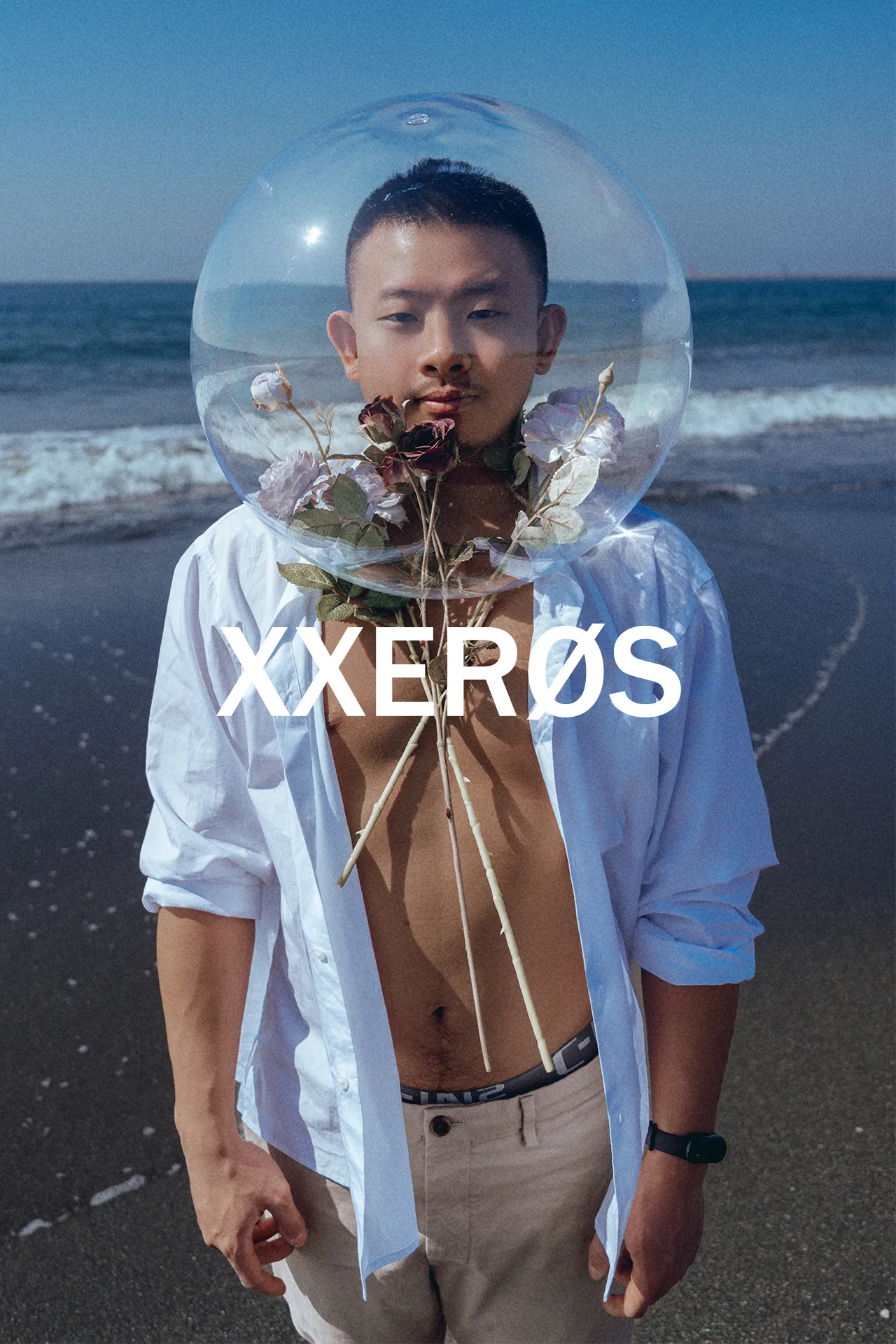 XXERØS Vol.04《RESONANCE》 | 玉米 6 玉米戴透明壓克力球頭罩立於台南小美軍海灘,白衫開扣,頸間植物,男體藝術攝影,宇宙拿鐵 Lattefotos